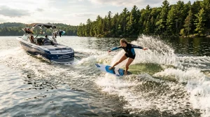 Surfing Magazine | PDR – Destinations, Gear & Technique Guides 4 Skilled surfer wakesurfing ropeless on boat wake across glassy freshwater lake